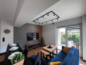 ein Wohnzimmer mit einem blauen Sofa und einem Tisch in der Unterkunft Apartament Helsinki in Zator