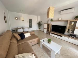 un salon avec un canapé et une télévision dans l'établissement Trimar - Apartamento céntrico con garaje, à Fuengirola