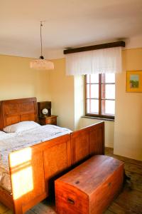 A lovely house in Vipava valley في فيبافا: غرفة نوم بسرير مع اطار خشبي وطاولة