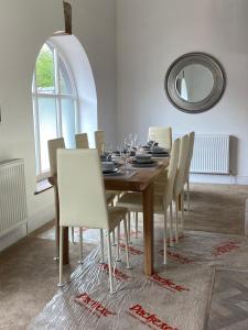 a dining room with a wooden table and chairs at The Mews - Family space, garden, parking, balcony, view in Adlington