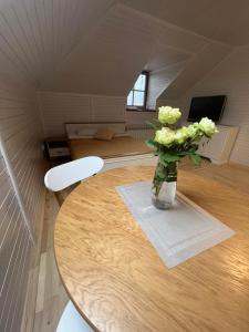 a vase of flowers sitting on a table in a room at Гостерія"Old Town" in Kamianets-Podilskyi