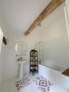 een badkamer met een wastafel, een bad en een spiegel bij La Première Vigne in Puycelci
