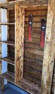 una estantería de madera con 2 tablas de snowboard en la pared en Chalet 8 couchages à 100m du bas des pistes et commerces, en Les Angles