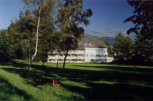 ein großes weißes Gebäude in der Mitte eines Feldes in der Unterkunft Hotel-Restaurant Sternen in Nesslau