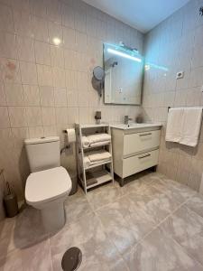 une salle de bain avec toilettes, lavabo et miroir dans l'établissement Trimar - Apartamento céntrico con garaje, à Fuengirola 10 autres photos