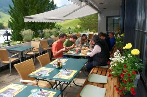 a group of people sitting at tables at a restaurant at Hotel-Restaurant Sternen in Nesslau