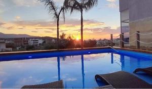 a large swimming pool with a sunset in the background at Villa Nefeli Prive in Ksamil