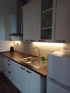 a kitchen with white cabinets and a sink at Dom Gościnny Przy Jeziorze in Gardna Wielka