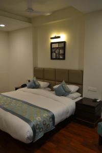 a hotel room with two beds and a table at Sobti Continental Bareilly in Bareilly