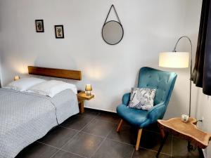 皮特爾角城的住宿－Charmant pied-à-terre coeur de ville，一间卧室配有一张床和一张蓝色椅子