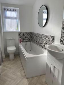 a bathroom with a tub and a toilet and a mirror at South Cottage - Garden, Views, Parking, Dogs, Cheshire, Walks, Family in Adlington