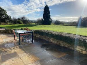 una mesa y sillas en un patio con césped en South Cottage - Garden, Views, Parking, Dogs, Cheshire, Walks, Family, en Adlington