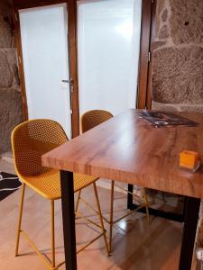 A aira da xoaniña في أياريز: طاولة وكراسي خشبية في الغرفة