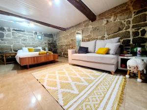 A aira da xoaniña في أياريز: غرفة معيشة مع أريكة وجدار حجري