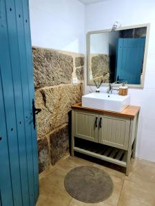 a bathroom with a sink and a mirror at A aira da xoaniña in Allariz