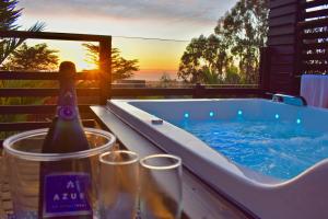 a hot tub with a bottle of wine and two glasses at ---- ESCAPADA DE LUJO PARA DOS ---- Casa Boutique Privada - Vistas al Océano - Parrilla y Fogón en Quincho Privado - Insumos desayuno - Tu estadía incluye GRATIS 1 Sesión de Hidromasaje & Cromoterapia bajo las estrellas en Jacuzzi Privado in Pichilemu
