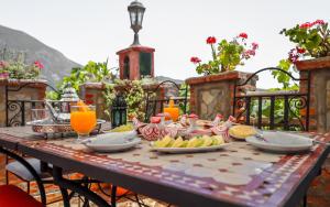 a table with food and drinks on a balcony at Dar Touijar in Chefchaouen