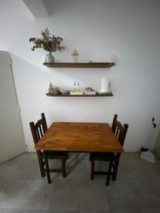 uma mesa de madeira e cadeiras num quarto em La Escala em Corrientes
