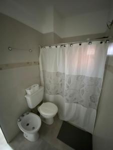 y baño con aseo y cortina de ducha. en La Escala en Corrientes