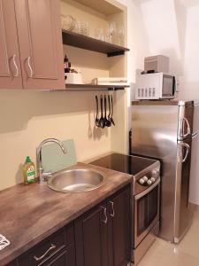 a kitchen with a sink and a stainless steel refrigerator at Slim apartman i sobe in Medulin