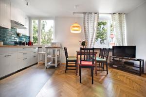 cocina y comedor con mesa y sillas en P&O Apartments Bielańska, en Varsovia