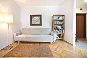sala de estar con sofá y estante para libros en P&O Apartments Bielańska, en Varsovia