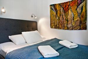 1 cama con 2 almohadas y una pintura en la pared en P&O Apartments Bielańska, en Varsovia