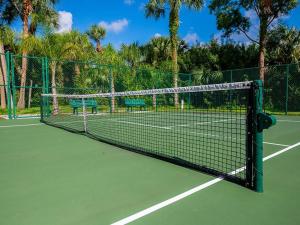 a tennis net on a tennis court with two benches at Social Distanсing Approved Nature Getaway! in Naples
