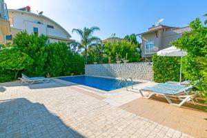 a swimming pool in front of a house at Paradise Town Villa Abel in Belek