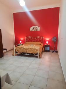 a bedroom with red walls and a bed in a room at Casa Vacanze Vista Mare in Agrigento