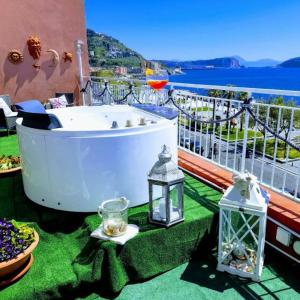 a bath tub on a balcony with a view of the water at Terrazza Miracapri in Pozzuoli