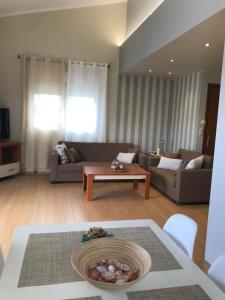 una sala de estar con un sofá y una mesa en georgia's cozy rooms #1, en Kavala