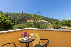 un tavolo e sedie su un balcone con vista di Olive tree apartment 1 a Prijevor