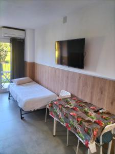 ベナルマデナにあるMinerva Evening Sun Studyのベッド2台、壁掛けテレビが備わる客室です。
