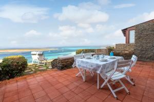 un tavolo e sedie su un patio con vista sull'oceano di Terrazza Capofalcone a Stintino
