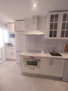 uma cozinha branca com armários brancos e um lavatório em Mirador Bajo de Guía em Sanlúcar de Barrameda