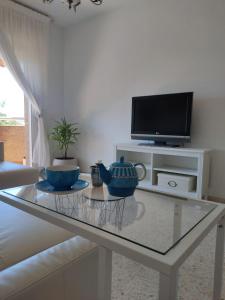 uma sala de estar com uma mesa de vidro e uma televisão em Mirador Bajo de Guía em Sanlúcar de Barrameda