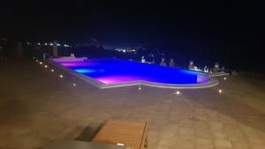 a large swimming pool at night with purple lights at B&B A Robba de Pupi in Agrigento