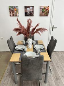 a dining room table with chairs and a table with plates at Prater Tree Apartment near city centre in Vienna