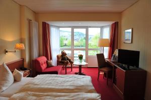 una mujer sentada en una silla en una habitación de hotel en Hotel Bären en Bernkastel-Kues