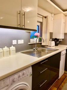 una cocina con fregadero y lavadora en Skye View Cottage, en Portree