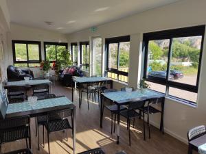 a restaurant with tables and chairs and windows at Kungshamns Vandrarhem in Kungshamn