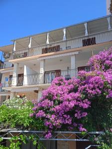 un edificio con fiori viola di fronte di Stonewood Dalmacija a Primošten