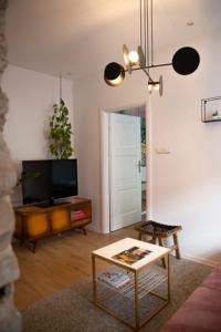 a living room with a tv and a table at Pink Rabbit Apart in Gdańsk