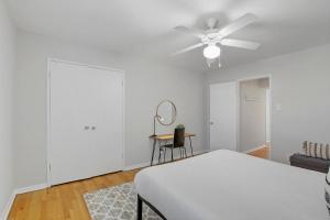 a white bedroom with a bed and a ceiling fan at 3BR Homey with Comfy Living Room Apartment - Bell 2G in Chicago