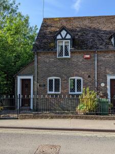 a brick house with a fence in front of it at Butchers Cottage in Ironbridge