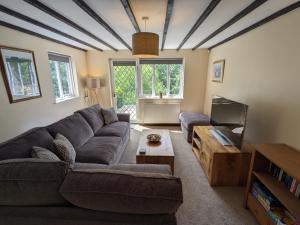 a living room with a couch and a tv at Butchers Cottage in Ironbridge