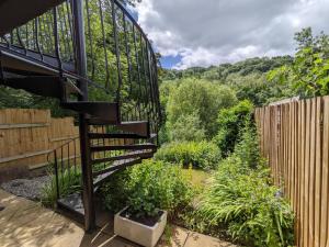 a spiral staircase in a garden with a fence at Butchers Cottage in Ironbridge