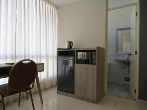 a room with a desk and a chair and a microwave at Casa Las Flores Ica in Ica