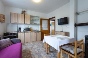 a living room with a table and a kitchen at House Vranić Plitvice in Rakovica